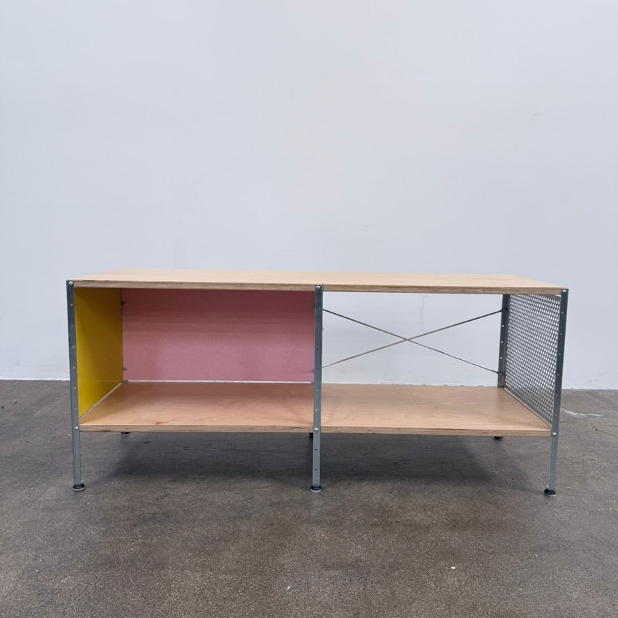 Herman Miller Eames Storage Unit featuring a low rectangular frame with plywood shelves, a yellow side panel, a pink back panel, and a perforated metal side.