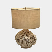 The Palecek Point Dume Table Lamp by Palecek features a clustered wooden bead base and a cylindrical beige fabric shade, offering relaxed coastal elegance for your space.