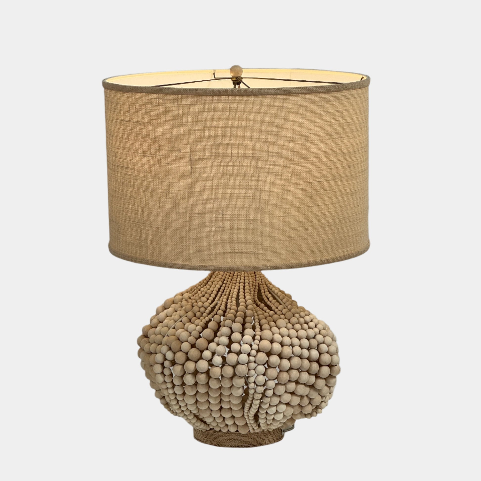 The Palecek Point Dume Table Lamp by Palecek features a clustered wooden bead base and a cylindrical beige fabric shade, offering relaxed coastal elegance for your space.