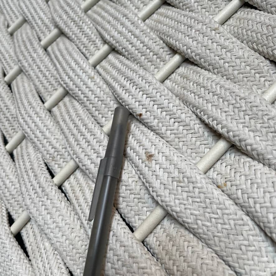 A Paola Lenti Mogambo Parasol on a white stand, designed by Paola Lenti.