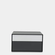 A rectangular gray and white lacquer box from B&B Italia, reminiscent of the Dado Night Table's minimalist design, features a glossy upper and matte lower section. This sleek piece serves as a stylish bedside companion, enhancing any modern space against a plain white background.