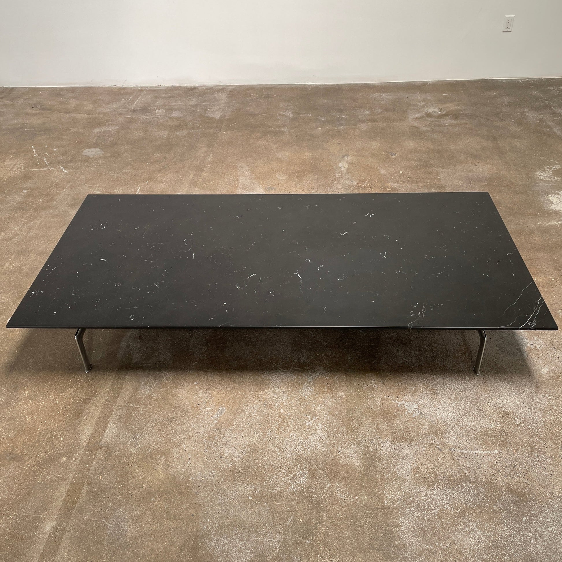 A minimalist rectangular black B&B Italia Diesis Coffee Table with metal legs, viewed directly from above, exudes timeless beauty against a plain white background.