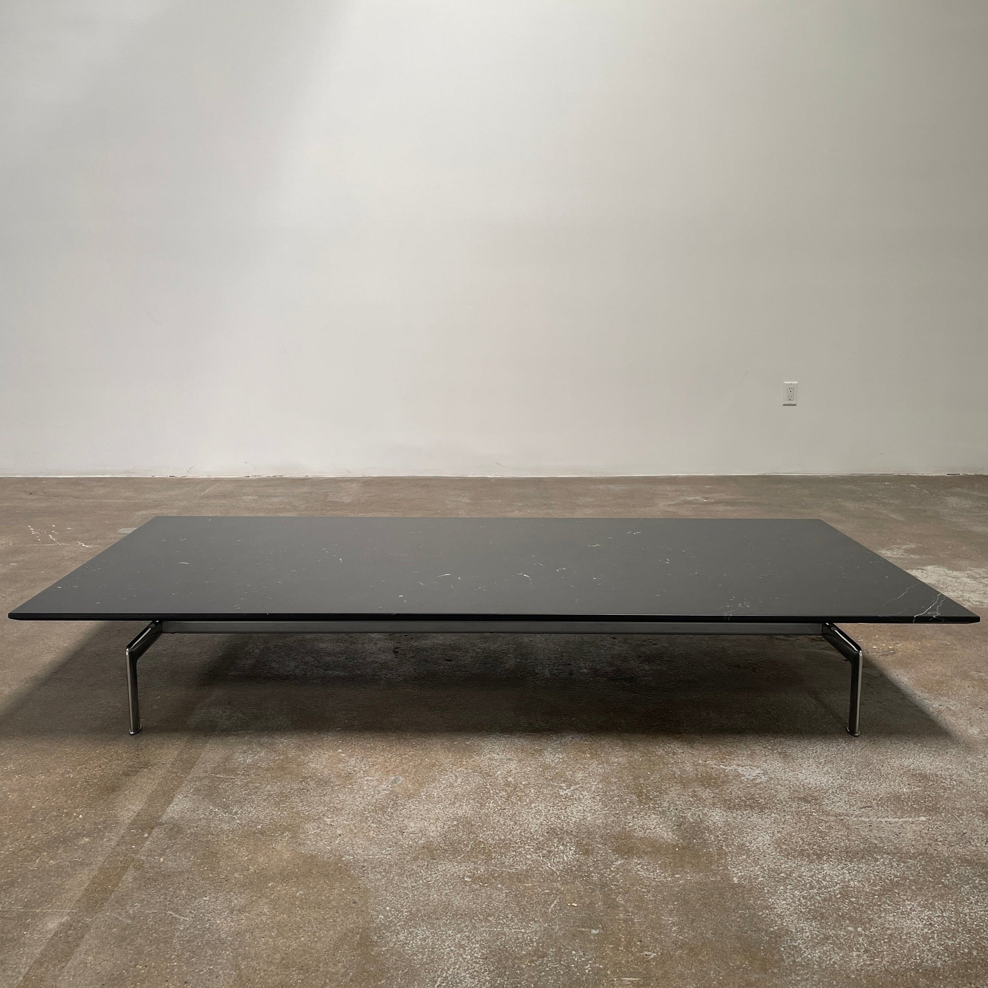 A minimalist rectangular black B&B Italia Diesis Coffee Table with metal legs, viewed directly from above, exudes timeless beauty against a plain white background.