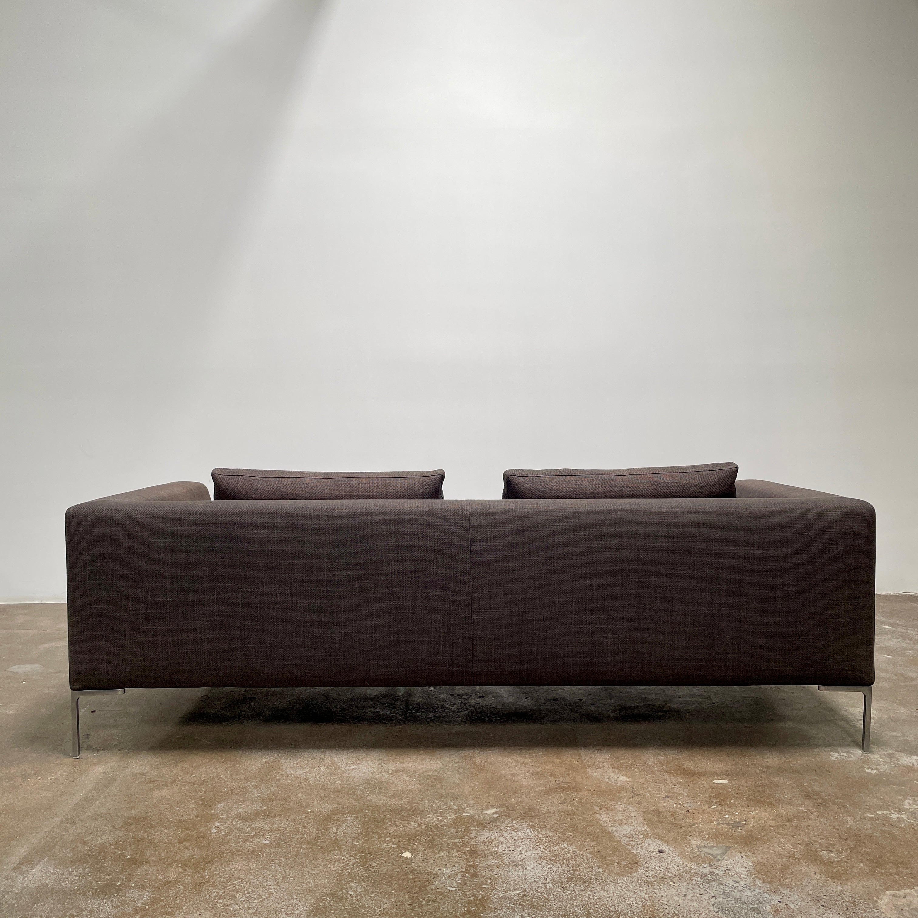 Elegant dark gray B&B Italia Charles Sofa with minimalist squared arms and two matching back cushions, showcased against a plain background.