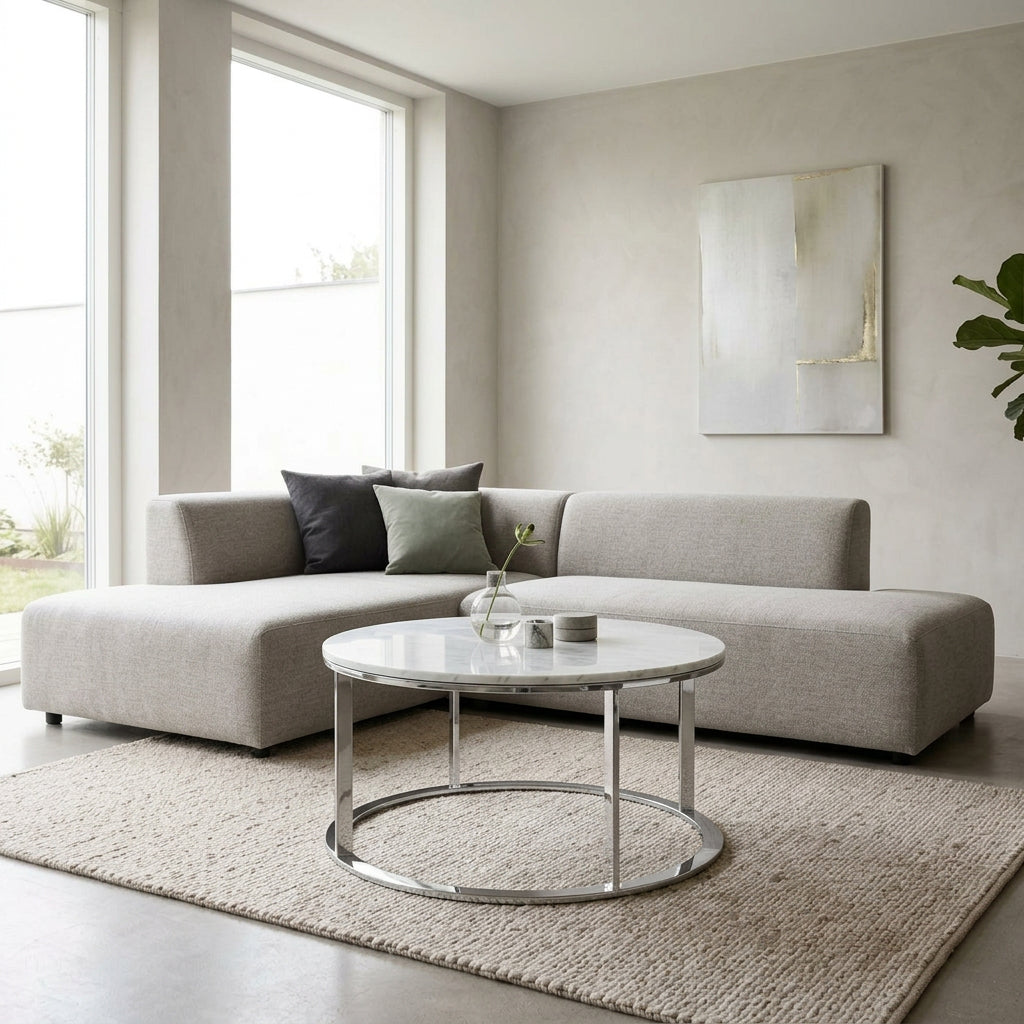 B&B Italia Mera Round Coffee Table with a white Carrara marble top and a dark metal circular base.