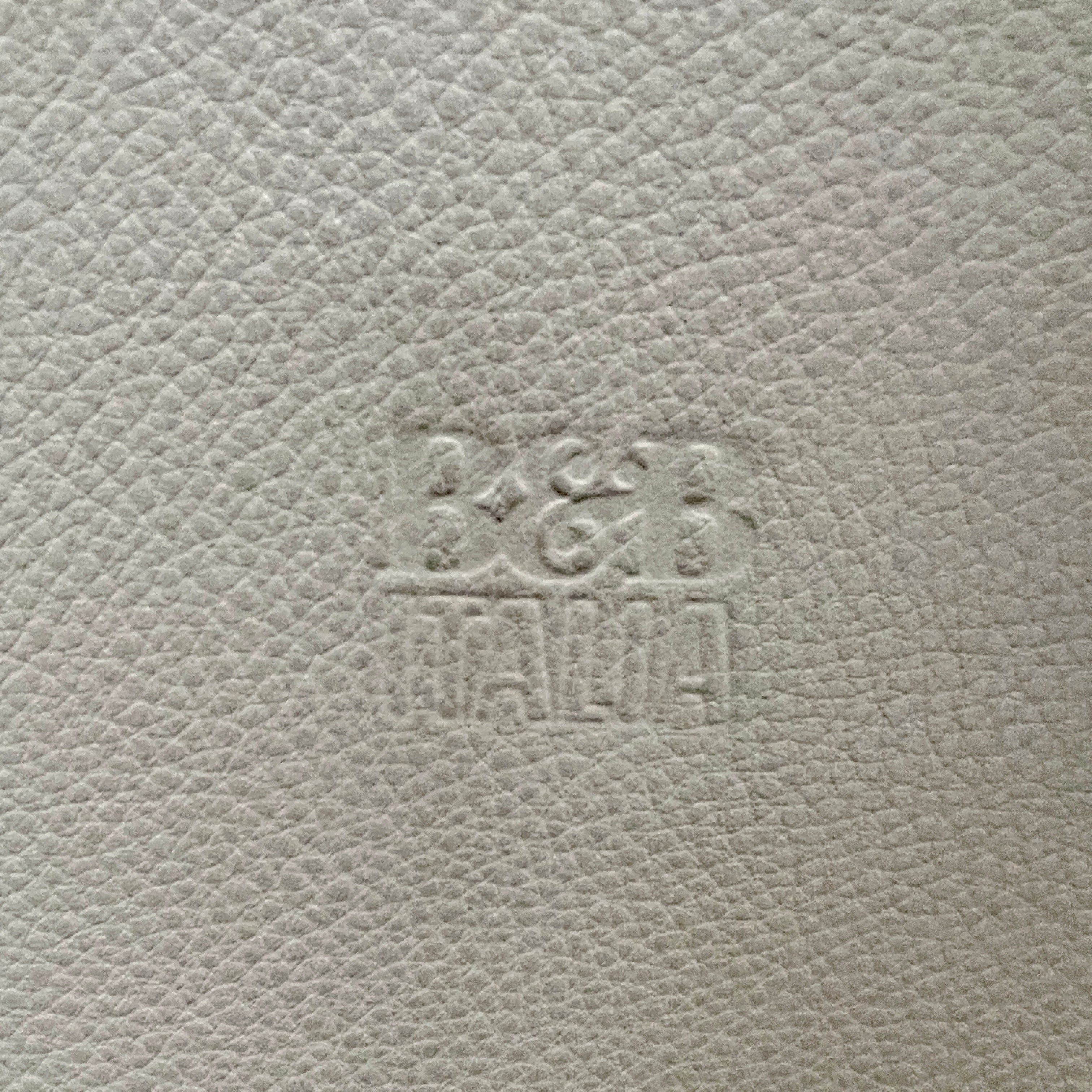 Six B&B Italia Vol au Vent Dining Chairs, embodying the elegance of Italian style, are arranged in two rows in an empty room with a concrete floor and a plain white wall.