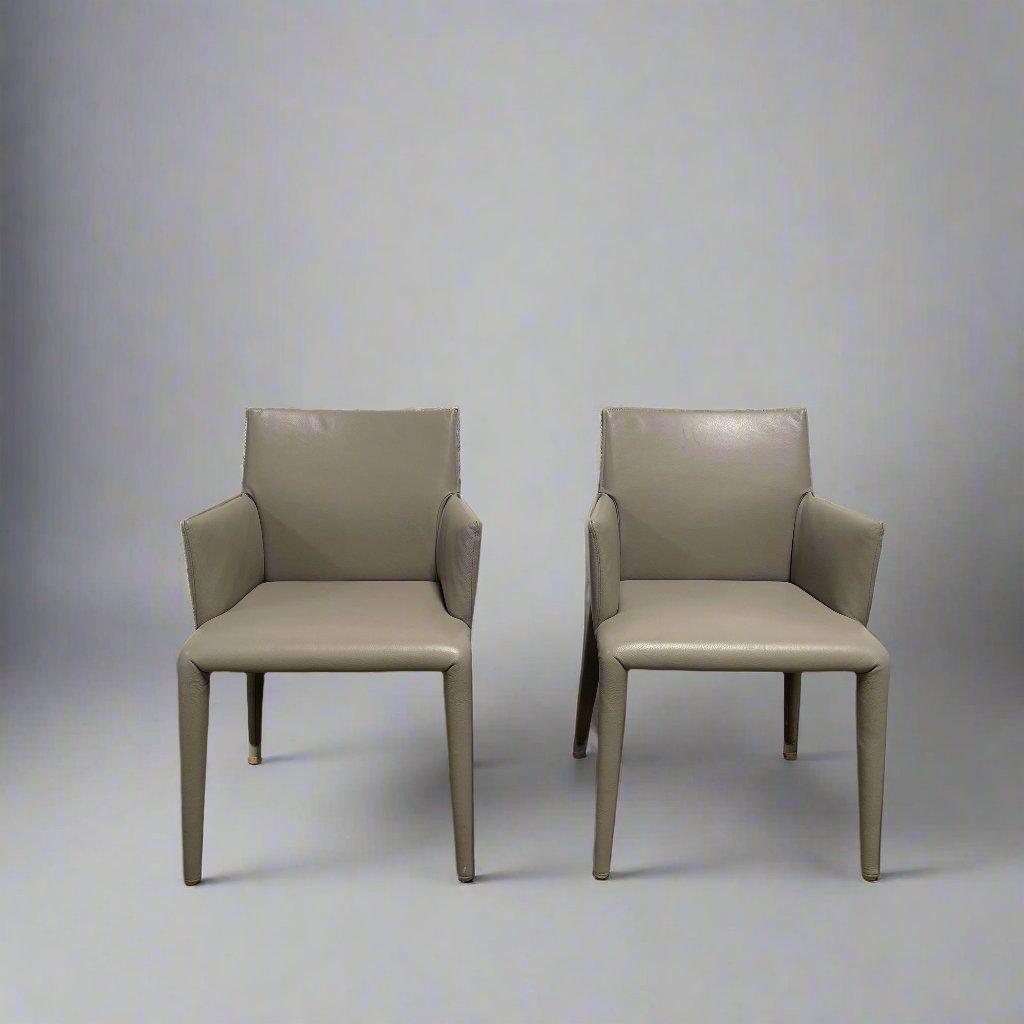 Six B&B Italia Vol au Vent Dining Chairs, embodying the elegance of Italian style, are arranged in two rows in an empty room with a concrete floor and a plain white wall.