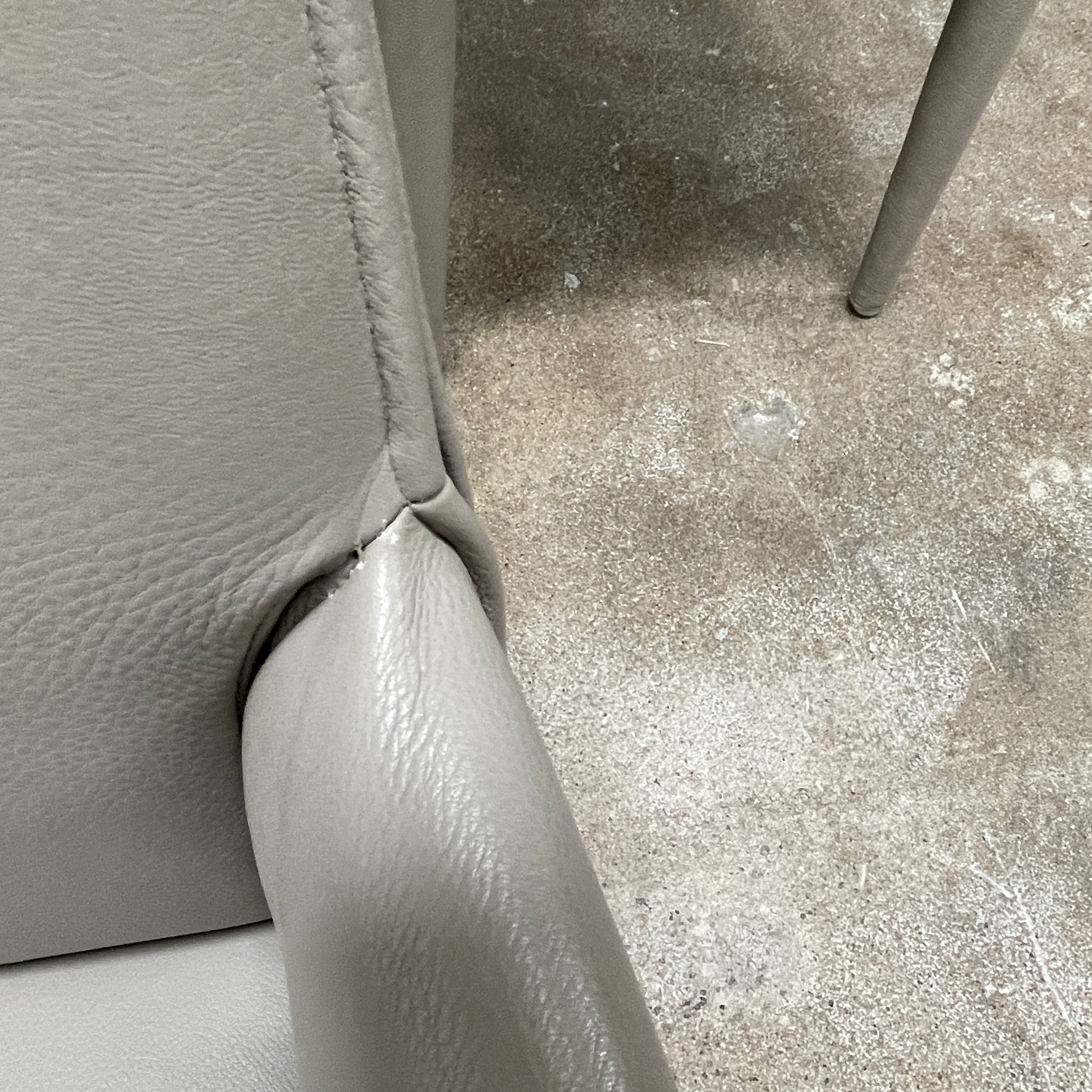 Six B&B Italia Vol au Vent Dining Chairs, embodying the elegance of Italian style, are arranged in two rows in an empty room with a concrete floor and a plain white wall.