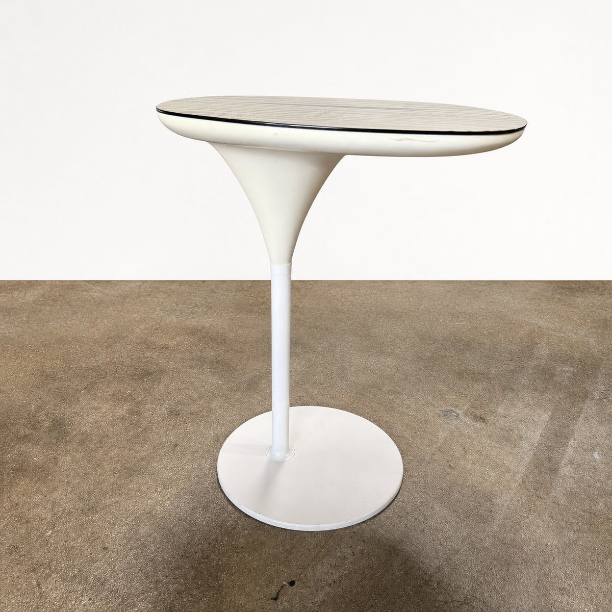 Moroso Bloomy Side Table with an oval, wood-grain top and a single, white pedestal base.