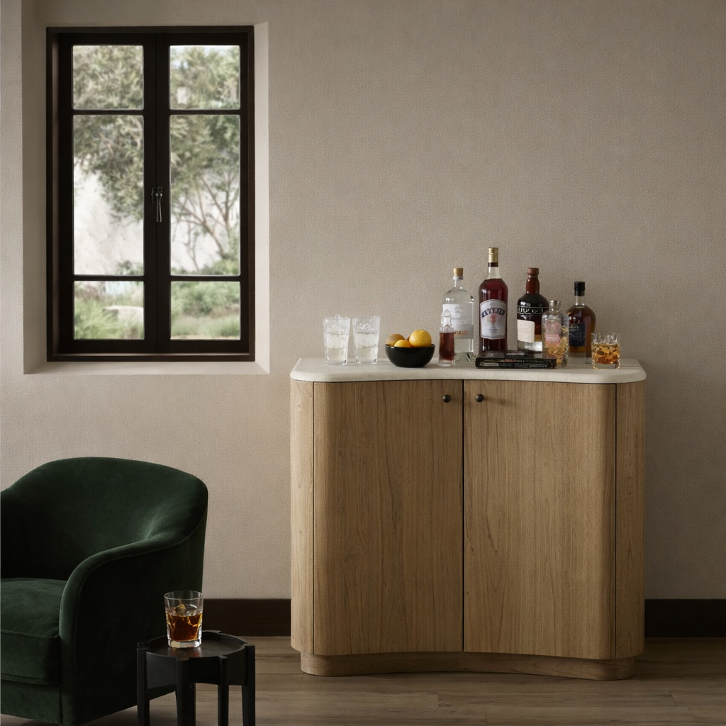 The Boa Small Cabinet by Fourhands features two doors, a gently curved front, light natural wood finish, and round handles, bringing contemporary style to any space.