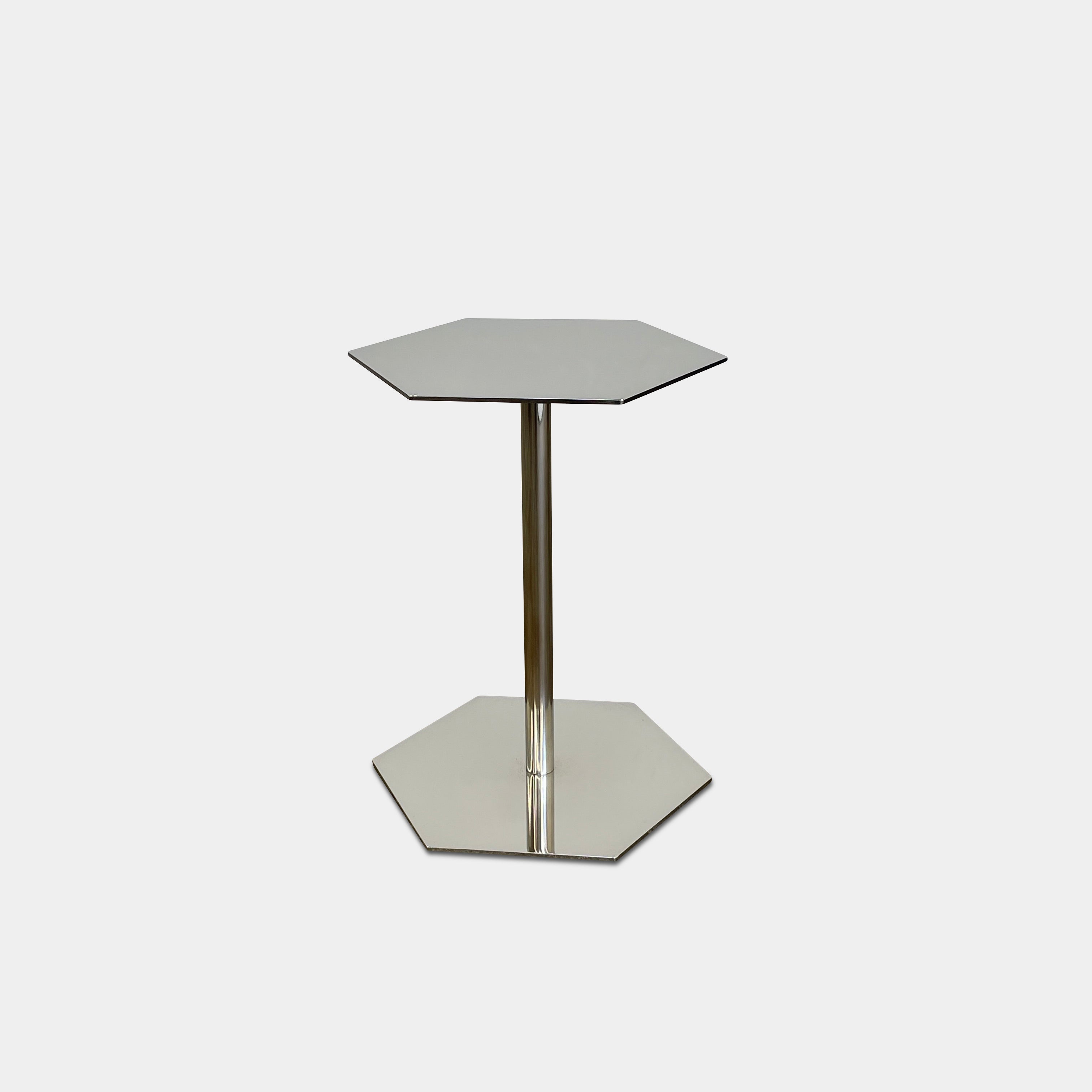 The Minotti Brisley Side Table by Rodolfo Dordoni features a stylish hexagonal metal surface supported by a central stand that flows into a matching base.