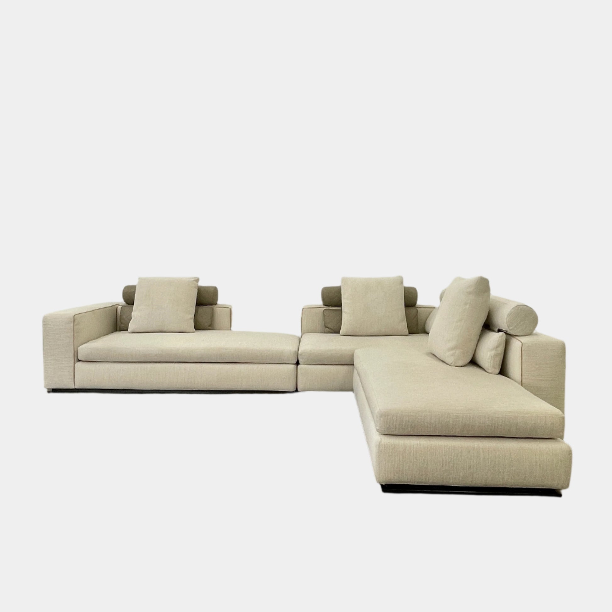 The Minotti Leonard 3 Piece Sectional by Minotti features an L-shaped beige design with three seat sections, multiple back and side cushions, and a right-side chaise lounge—ideal for an elegant living space—shown on a plain white background.