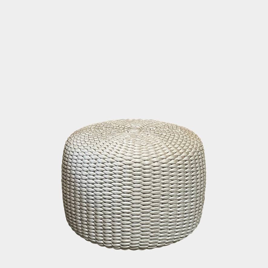 A Paola Lenti Nido ottoman, designed for outdoor seating, is showcased against a white background.