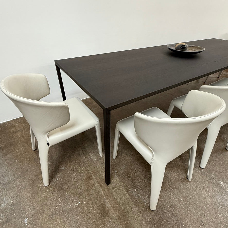 The Arco Slim Table by Arco is a minimalist rectangular table with a thin, flat surface and four slender legs, made from steel sandwich construction with a lightweight honeycomb core, shown against a plain white background.