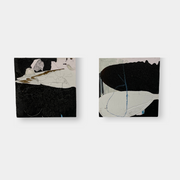The Diptych, "Jose Is Talking To The Neighbor" by Artist, features abstract paintings with a striking interplay of black, white, and gray. The left canvas has angular shapes contrasted by more rounded forms on the right, set against a plain white background.