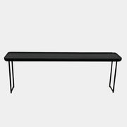A minimalist black bench with a rectangular seat and slim metal legs echoes the elegant design of the Cassina Torei Occasional Table in Black Ash by Cassina, displayed against a plain white background.
