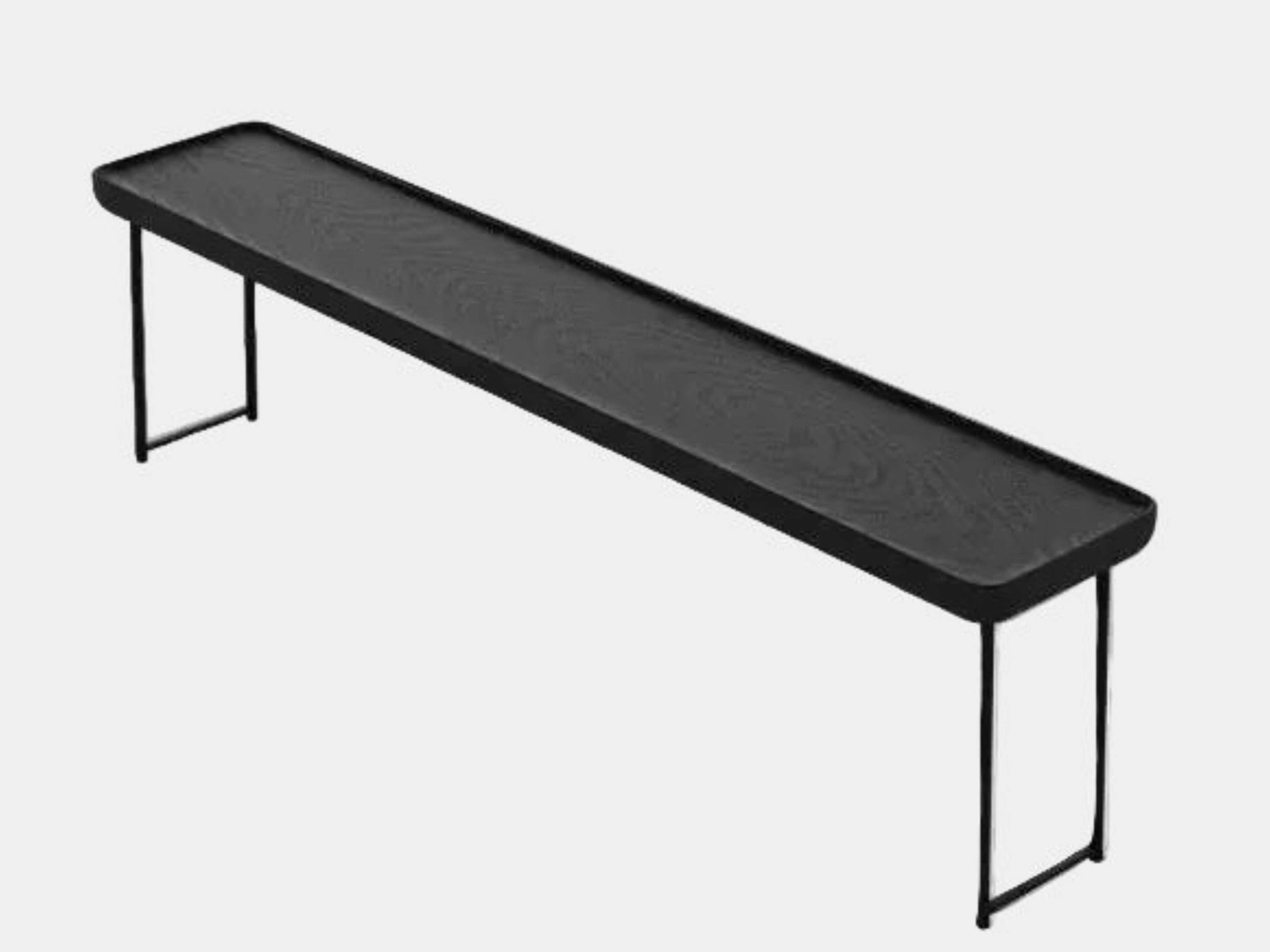 A minimalist black bench with a rectangular seat and slim metal legs echoes the elegant design of the Cassina Torei Occasional Table in Black Ash by Cassina, displayed against a plain white background.
