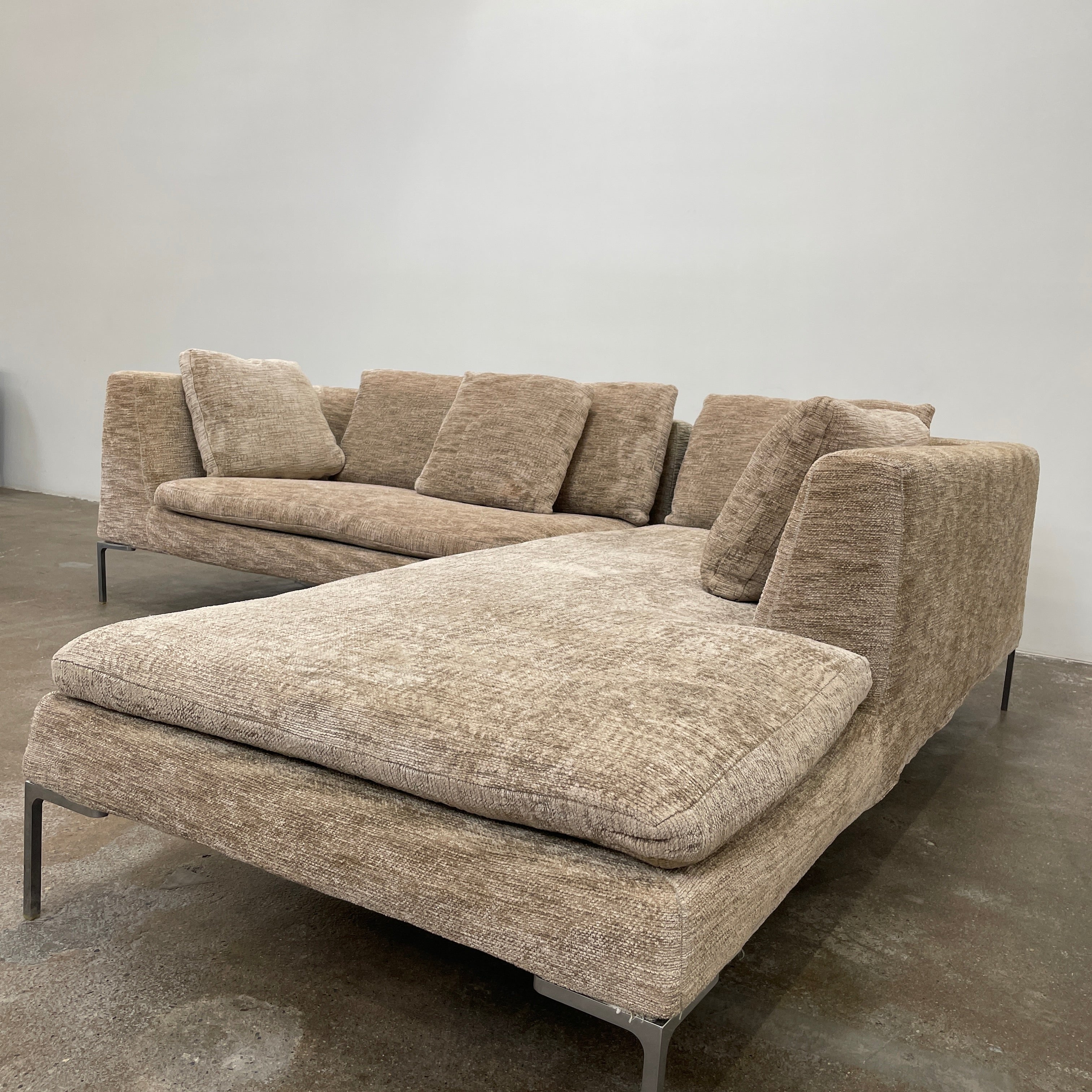 Introducing the B&B Italia Charles Sectional by Modern Resale: This beige L-shaped sectional sofa features textured fabric and stylish thin black metal legs. Set against a plain white background, it embodies modern elegance and timeless design.