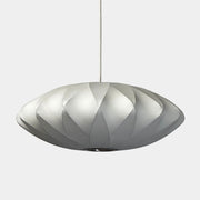 A medium Herman Miller Nelson Saucer Crisscross Bubble Pendant in white hangs before a wooden slat partition and beige sofa.