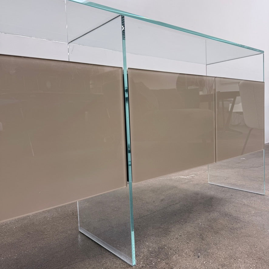 A long Gallotti & Radice Air Console Table featuring a clear glass frame and four opaque taupe storage cabinets.