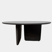 The B&B Italia Tobi-Ishi Outdoor Dining Table by B&B Italia features a modern round black design with a flat top and two asymmetrical base supports, inspired by Zen aesthetics, set against a plain light background.