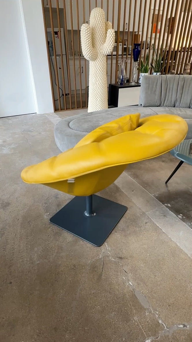 The Moroso Bohemian Low Armchair by Moroso features mustard yellow tufted leather upholstery, a matching cushion, and a black metal pedestal base, shown against a plain white background.