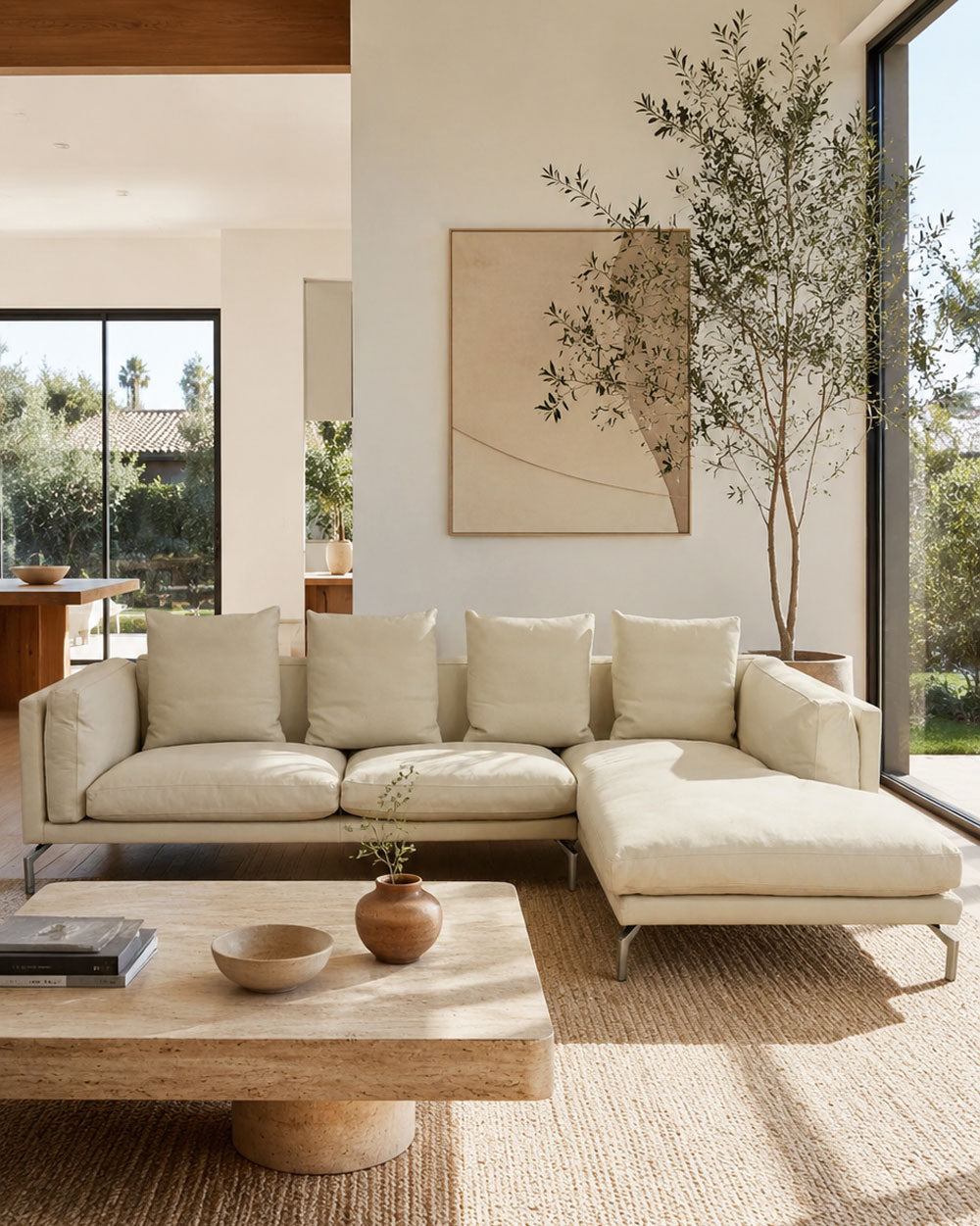 The DWR Como Sectional Sofa by DWR, in beige, features five back cushions and metal legs, showcasing Italian designer inspiration against a white background.