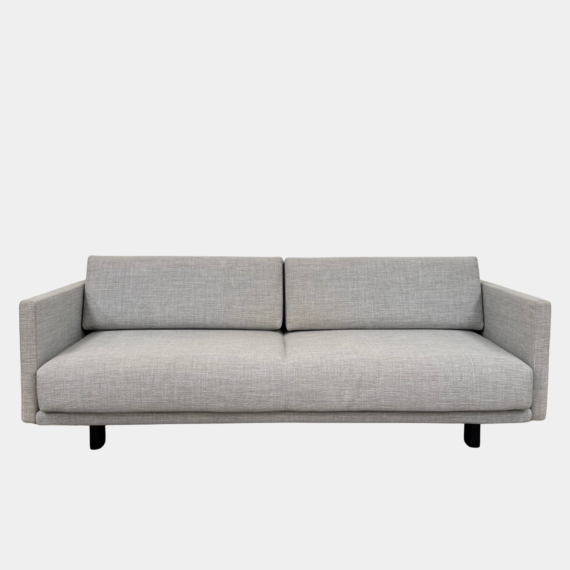 The DWR Tuck Sleeper Sofa by DWR features modern light gray fabric, straight arms, and black legs—ideal for a guest room. Shown against a plain white background.