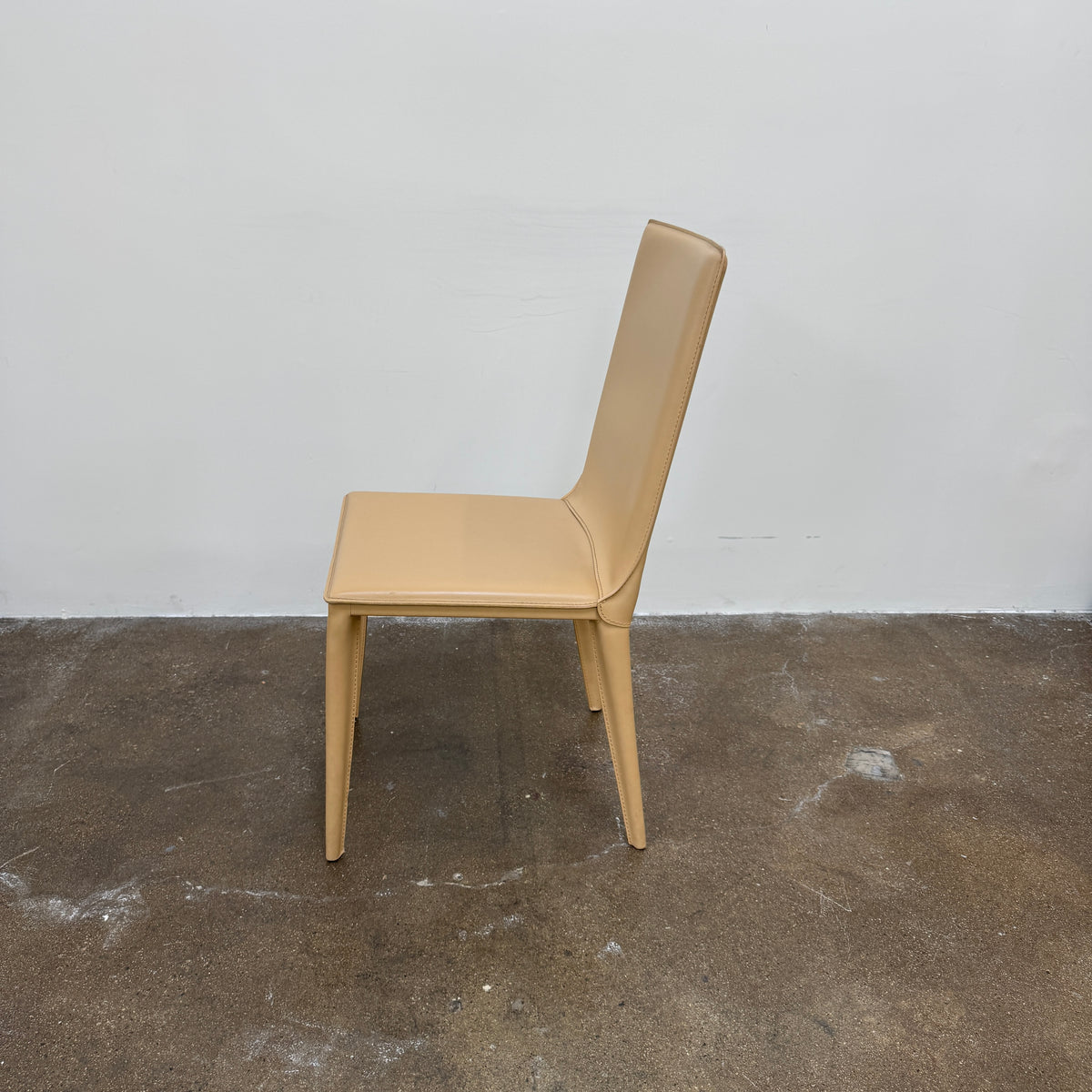Eight light-tan Frag Bottega leather dining chairs arranged in two rows.