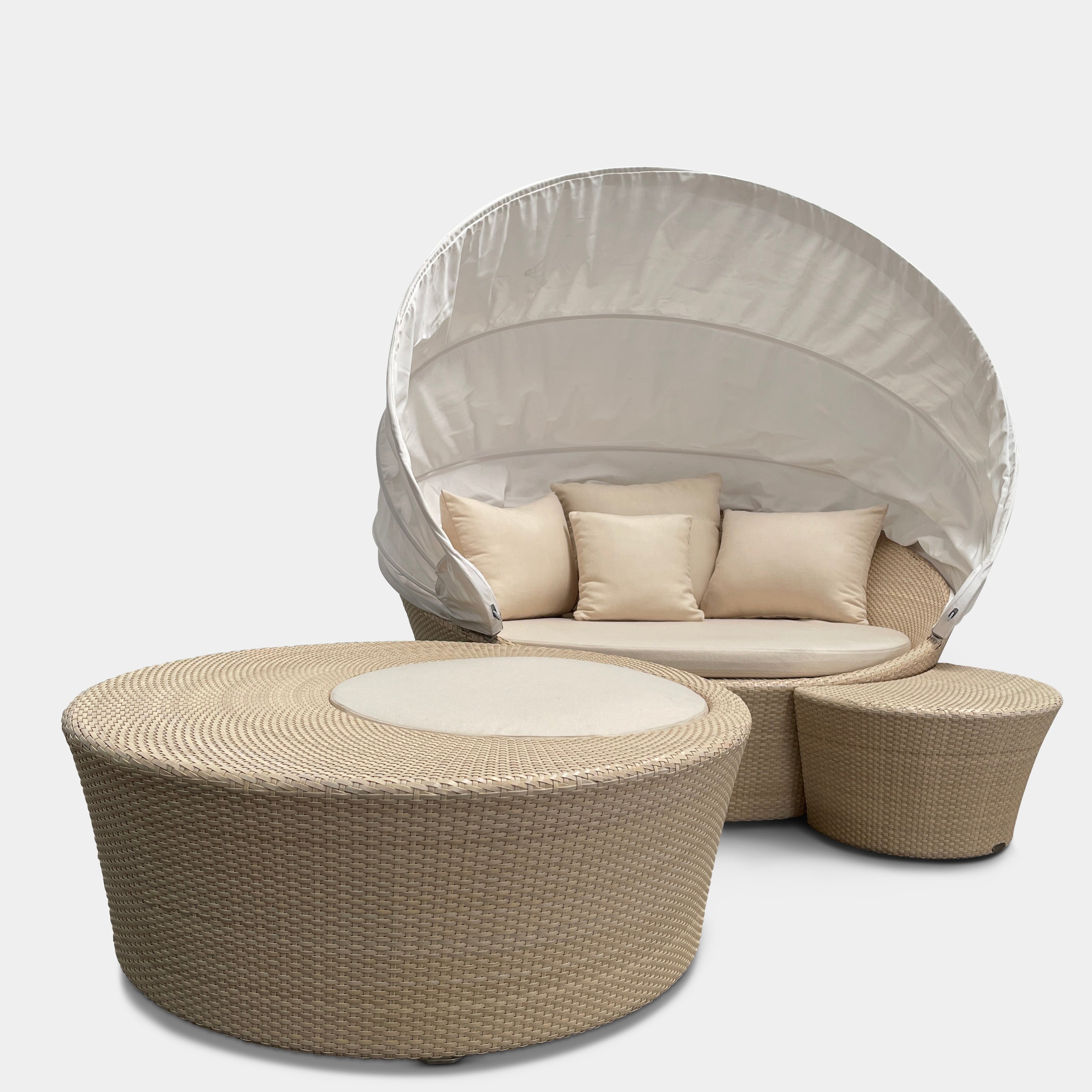 Experience the elegance of Richard Frinier Design with Dedon's Orbit Swivel Sofa Set, including a curved sofa with an adjustable canopy, ottoman, and side table. Cream-colored cushions add style and comfort to your outdoor ensemble.