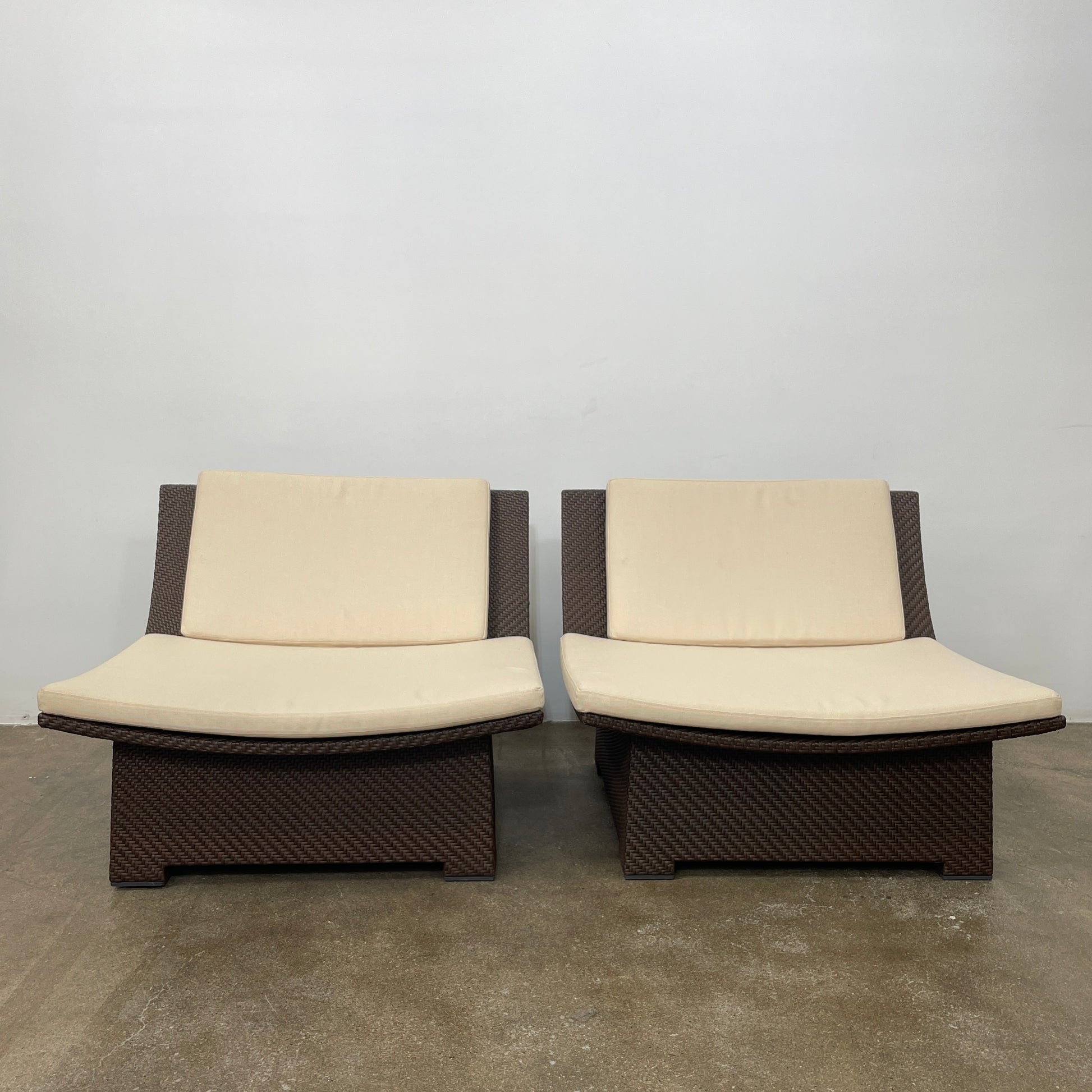 The Dedon Spa Outdoor Lounge Chairs set features two cream-cushioned seats made with proprietary fiber, beautifully displayed side by side against a simple white backdrop.