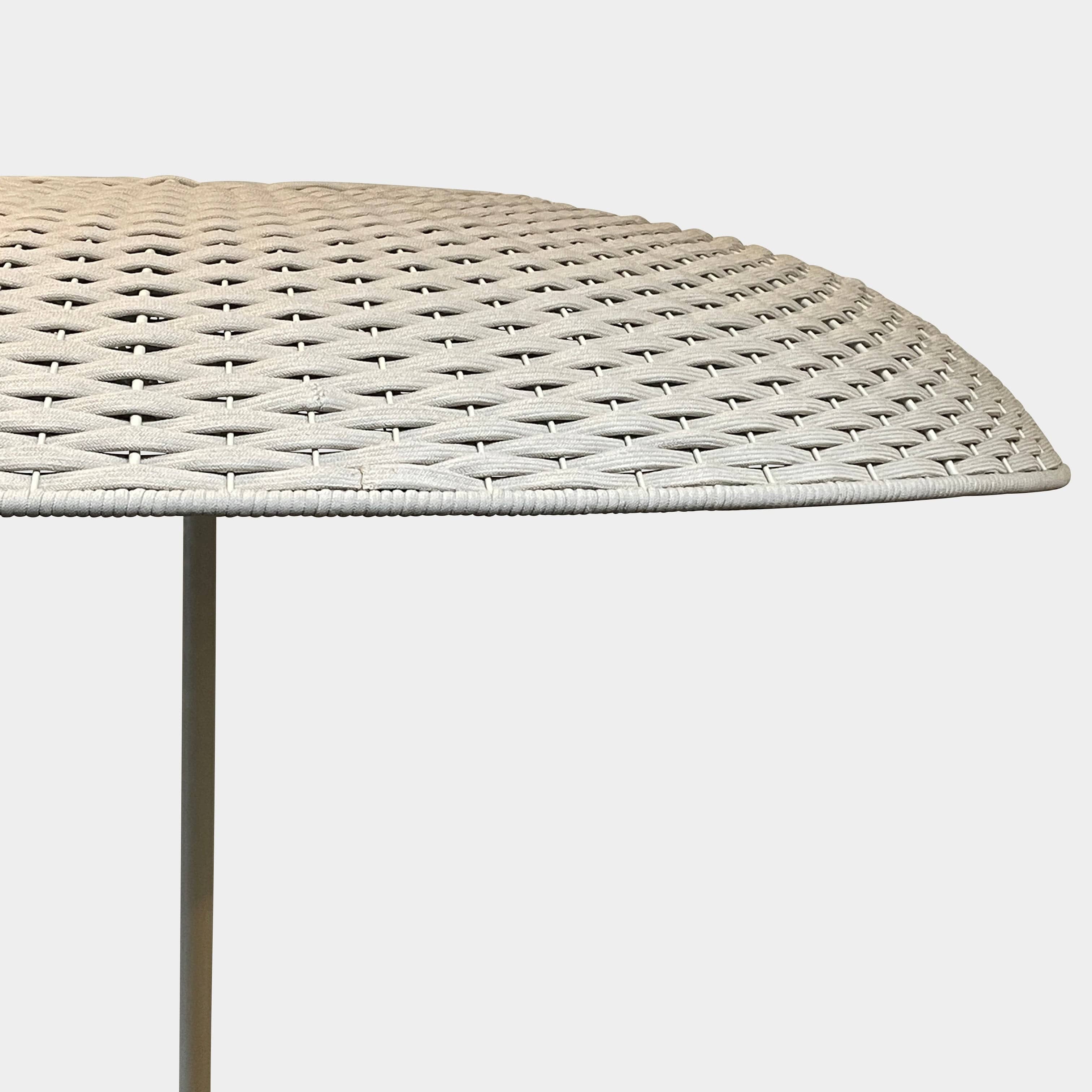 A Paola Lenti Mogambo Parasol on a white stand, designed by Paola Lenti.