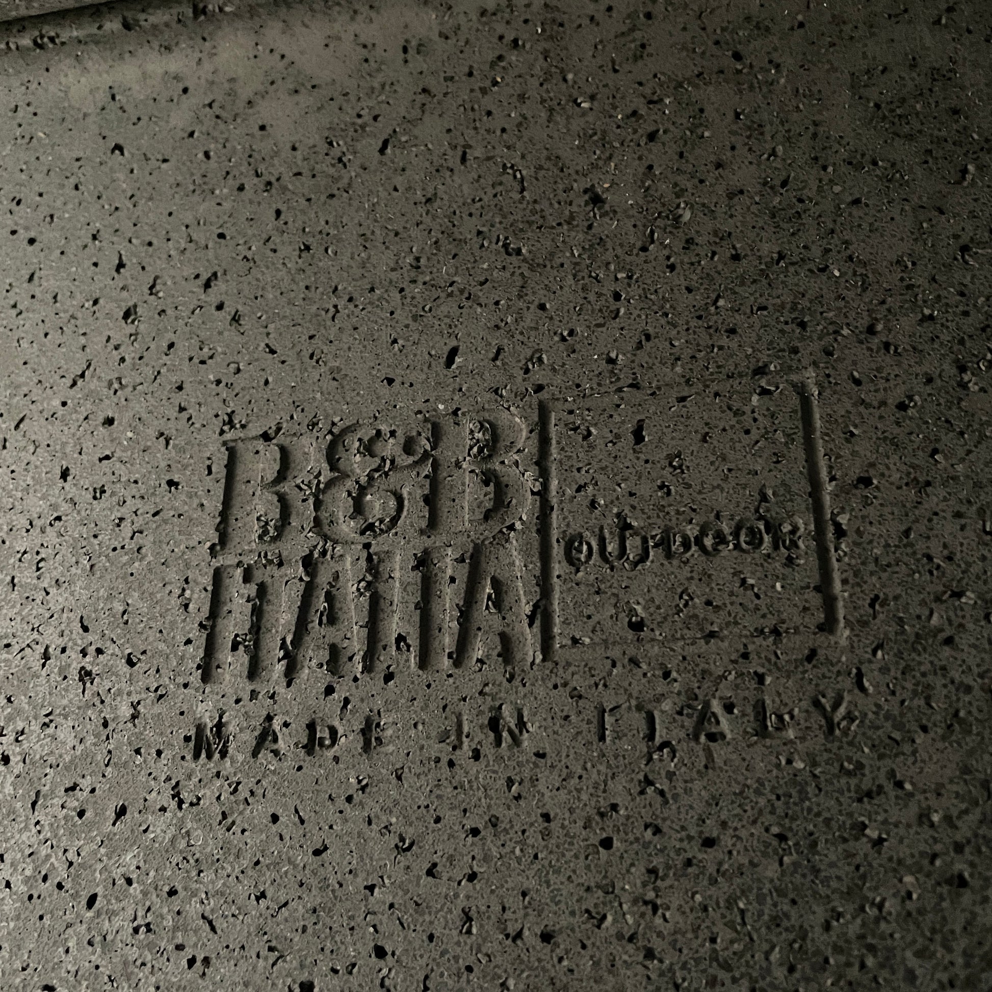 A rectangular black coffee table with asymmetrical supports on a white background, reminiscent of the B&B Italia Tobi-Ishi Outdoor Coffee Table (hold) by B&B Italia.