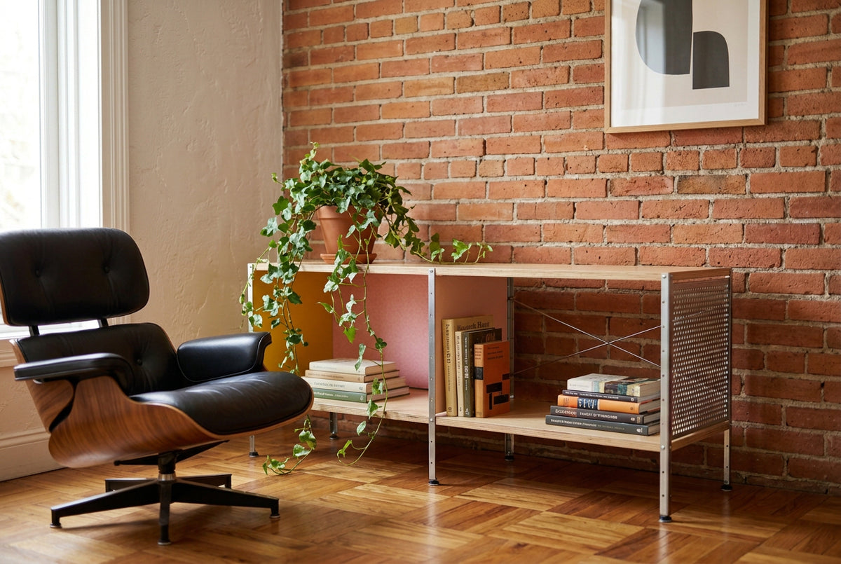 Herman Miller Eames Storage Unit featuring a low rectangular frame with plywood shelves, a yellow side panel, a pink back panel, and a perforated metal side.