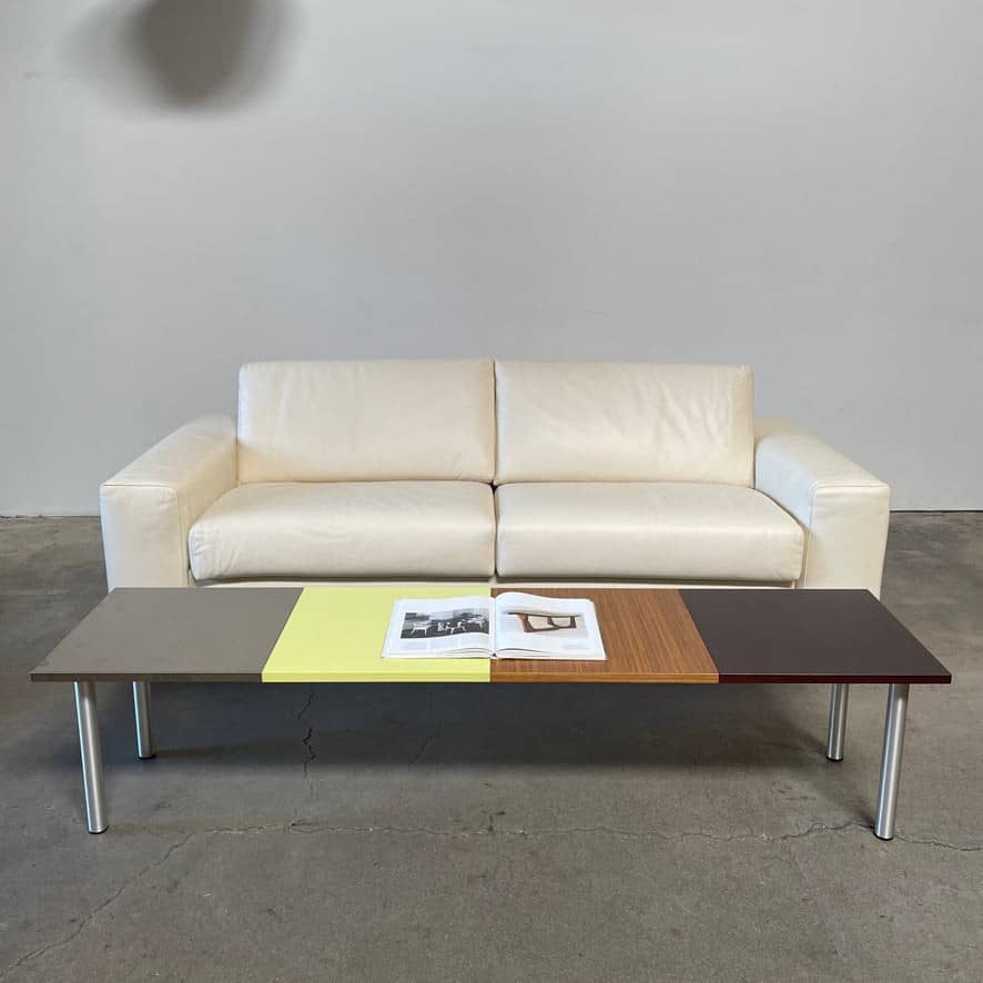 The Mazzei Multi-Panel Table by Mazzei is a contemporary design featuring a bench with a vibrant yellow, green, and blue top that adds functionality to any space.