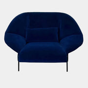 The Ligne Roset Paipai Armchair by Ligne Roset features a navy blue velvet finish, curved cocoon-like seat, matching rectangular cushion, slim black legs, and premium foam construction, displayed against a plain background.