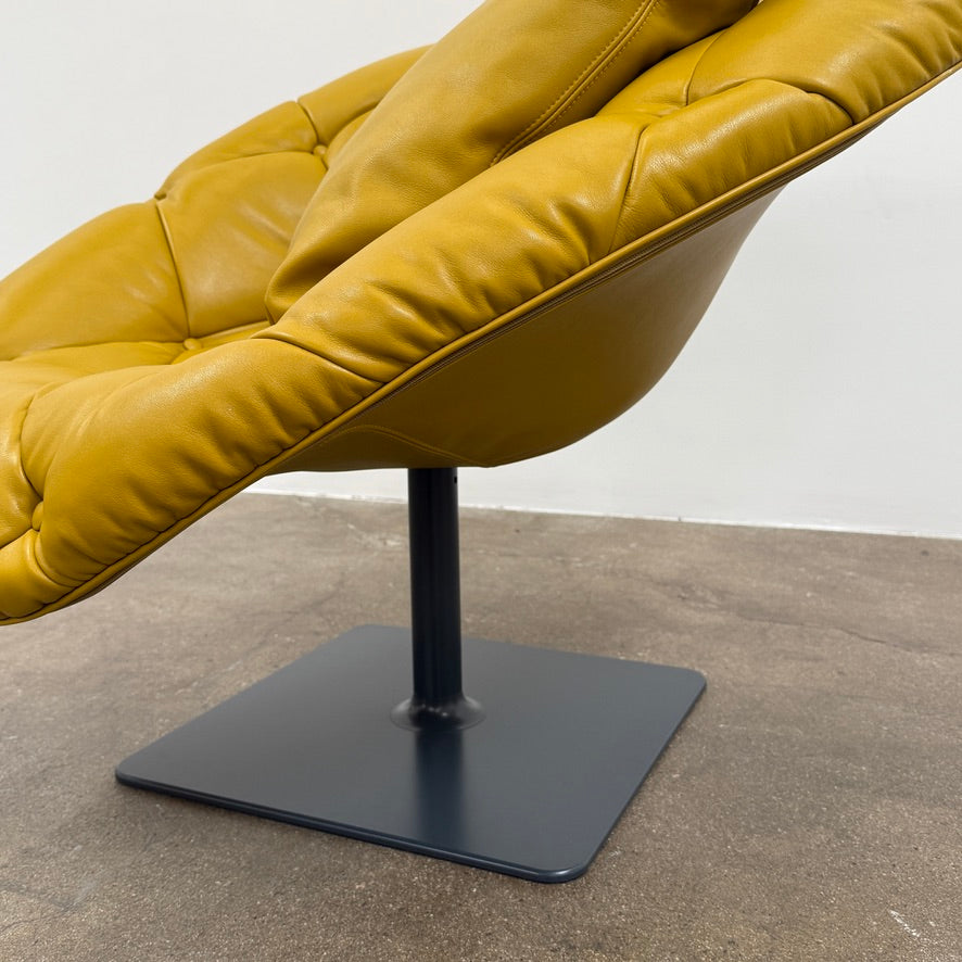 The Moroso Bohemian Low Armchair by Moroso features mustard yellow tufted leather upholstery, a matching cushion, and a black metal pedestal base, shown against a plain white background.