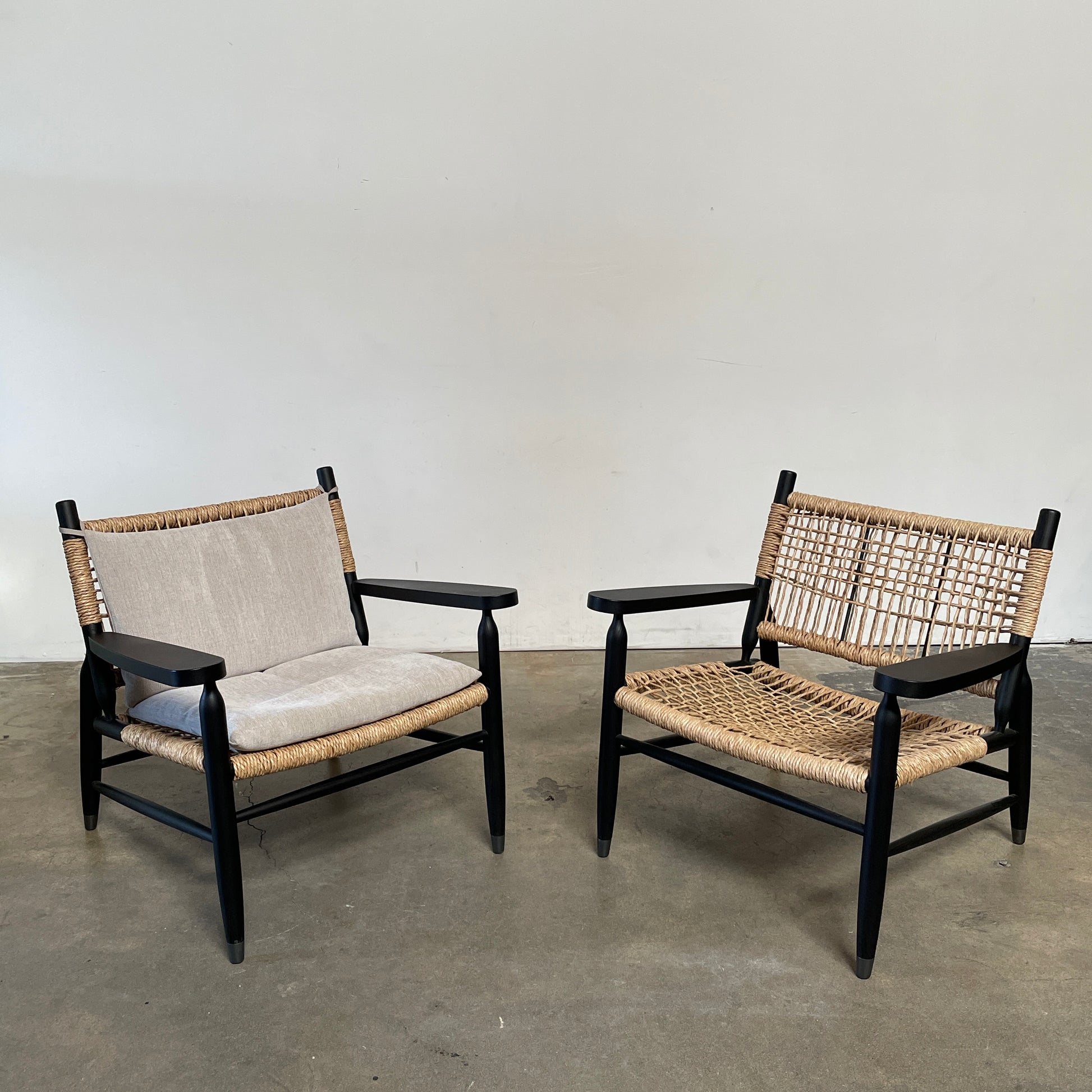 Two hand-crafted Flexform Tessa Lounge Chairs with black frames and neutral-tone cushions on a white background.