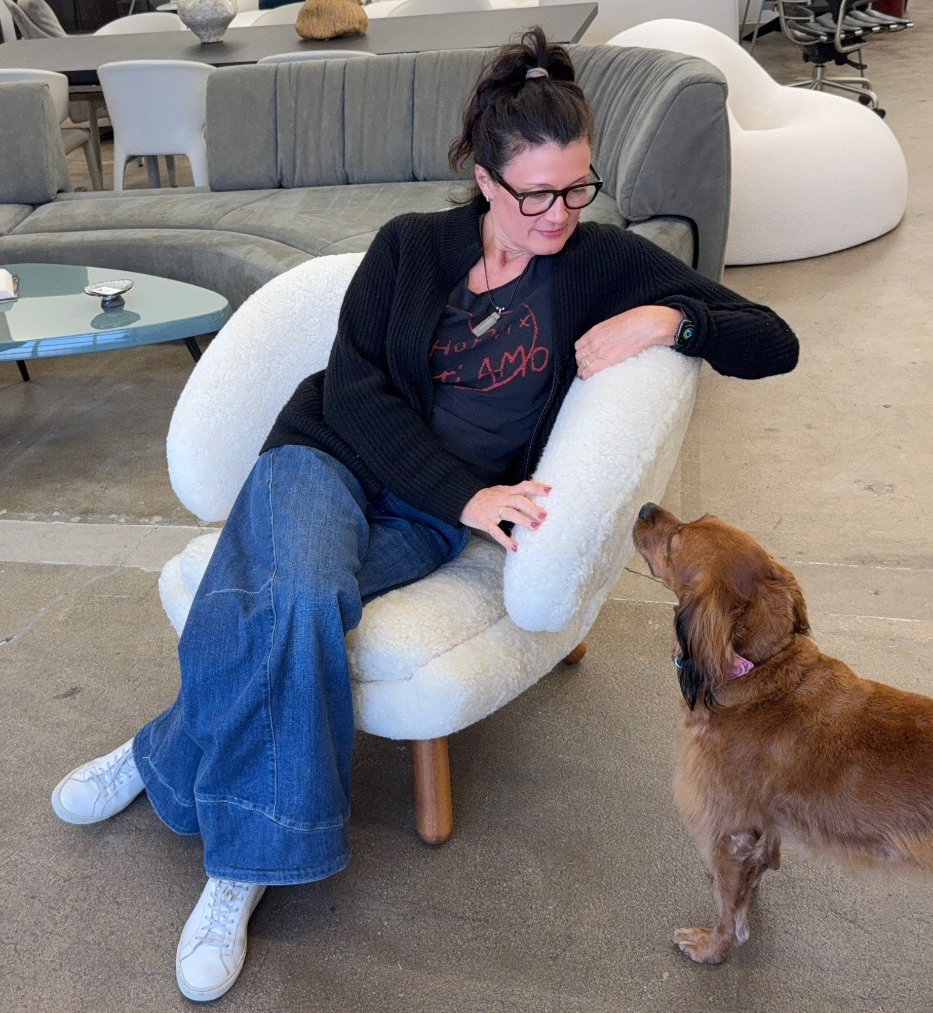 The House of Finn Juhl Finn Juhl Pelican Chair Sheepskin, with curved armrests and wooden legs, is displayed against a plain white background.