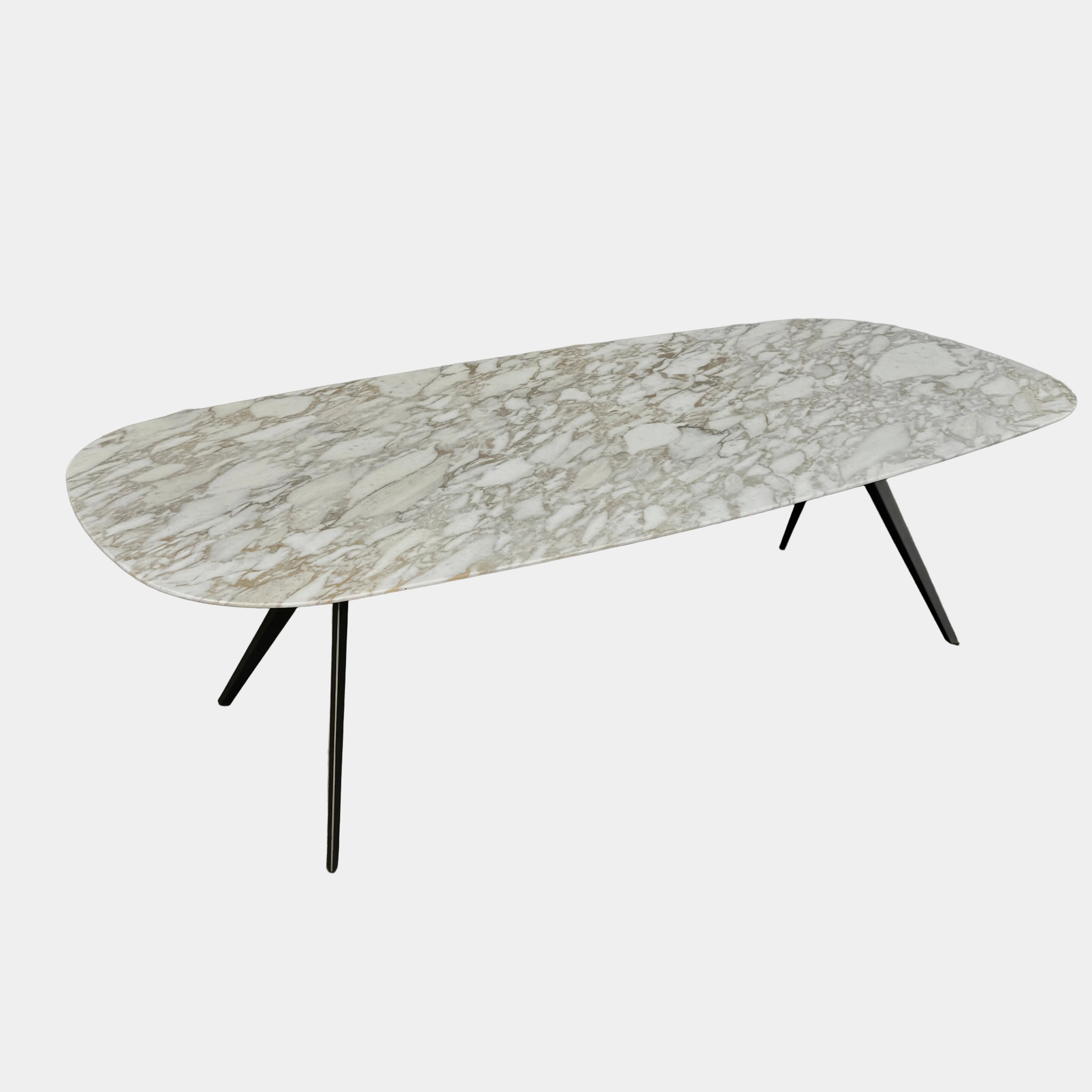The Flexform Zefiro Dining Table by Flexform features a rectangular Calacatta Gold marble top with rounded edges and four black angled legs, shown on a plain white background.
