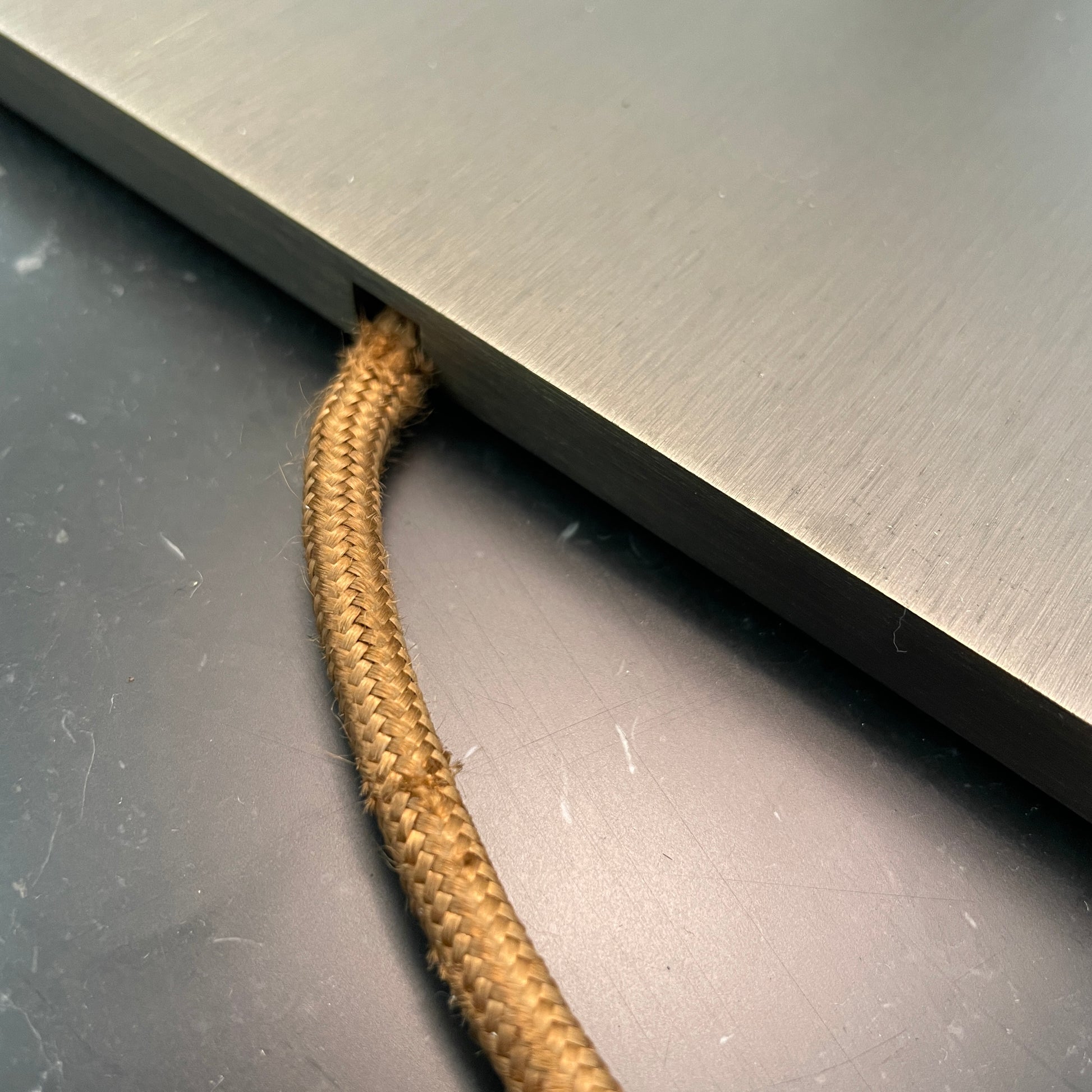 Introducing the Flos Metropolitan Table Light by Flos: a chic table lamp with a rectangular shade adorned with a diamond pattern, gracefully positioned on a square base.