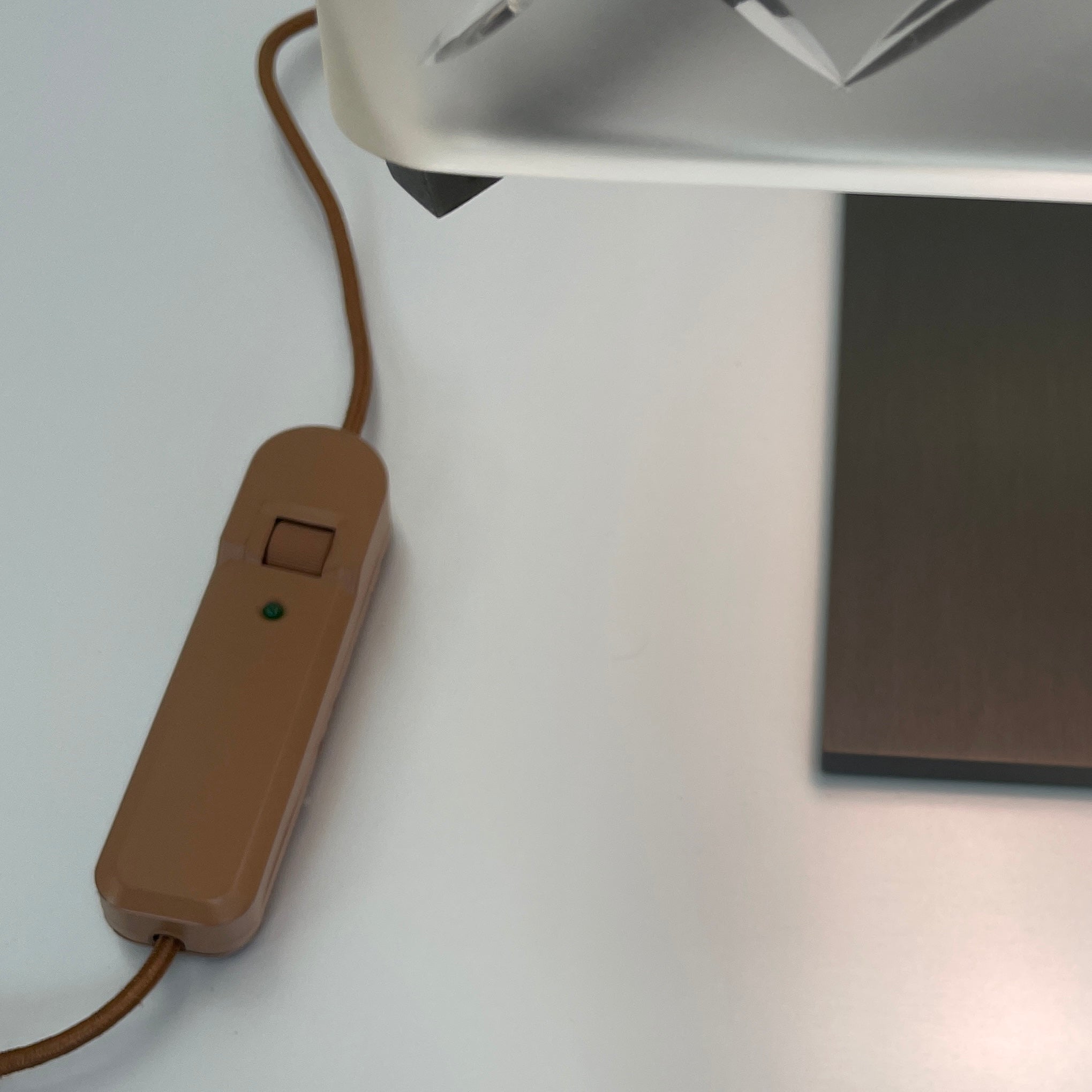 Introducing the Flos Metropolitan Table Light by Flos: a chic table lamp with a rectangular shade adorned with a diamond pattern, gracefully positioned on a square base.