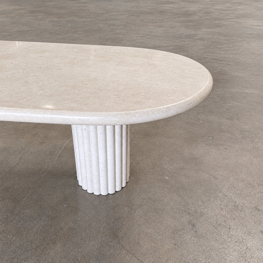 Form LA Fluta Oval Dining Table in Crema Marfil with a smooth top and two fluted cylindrical pedestals inspired by Roman architecture.