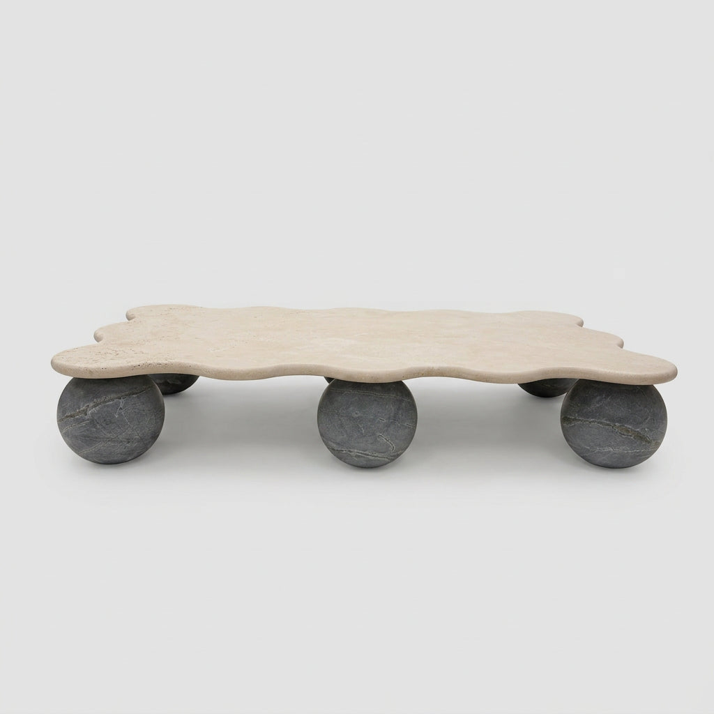 Form(LA) Palla Rectangle Coffee Table with a wavy-edged stone top supported by three spherical stone legs.