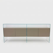 A long Gallotti & Radice Air Console Table featuring a clear glass frame and four opaque taupe storage cabinets.
