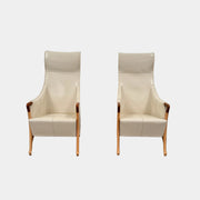 The Giorgetti “Progetti” Bergère / High-Back Lounge Chair by Giorgetti features light beige upholstery, wooden armrests and legs, and elegant ivory saddle leather accents, all inspired by the sophisticated Progetti collection, and is showcased against a plain white background.