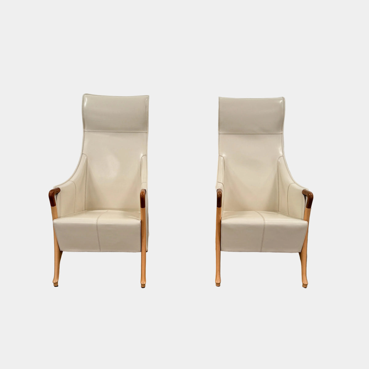 The Giorgetti “Progetti” Bergère / High-Back Lounge Chair by Giorgetti features light beige upholstery, wooden armrests and legs, and elegant ivory saddle leather accents, all inspired by the sophisticated Progetti collection, and is showcased against a plain white background.