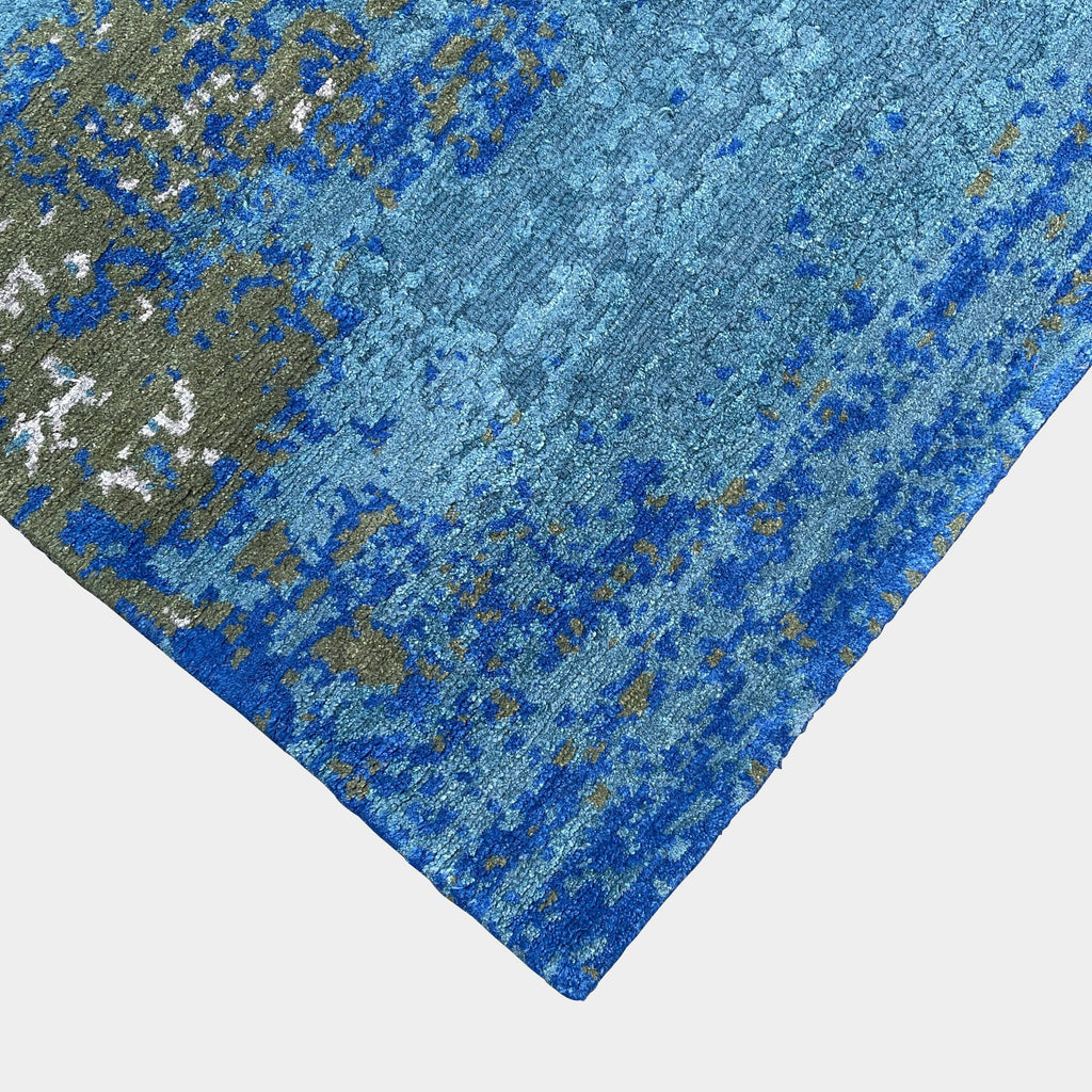A Delinear Pixilated Rug made of pure Himalayan wool in blue and gold colors placed on a white background.