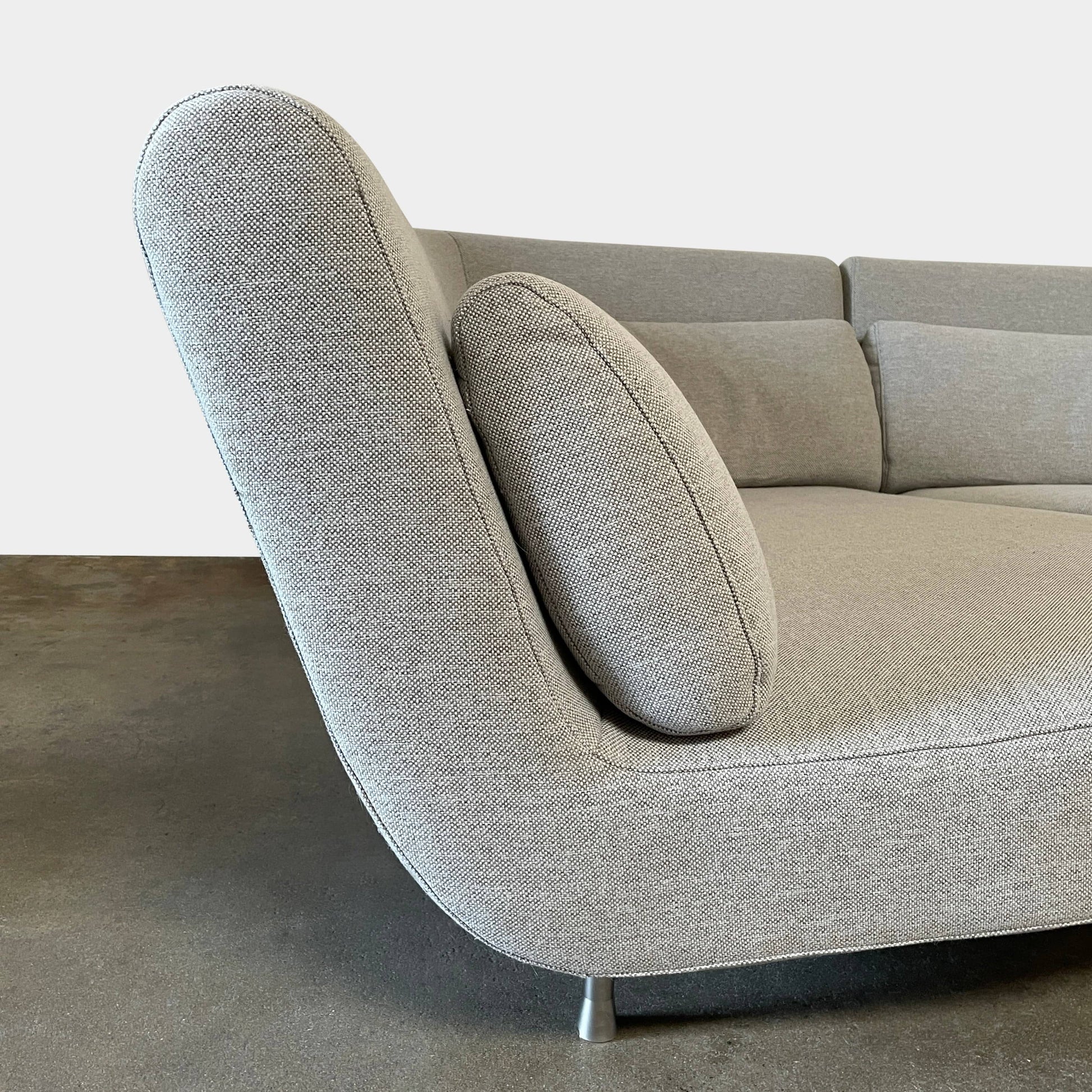 Modern curved Ligne Roset Yang Sectional sofa in durable wool fabric, isolated on a white background.