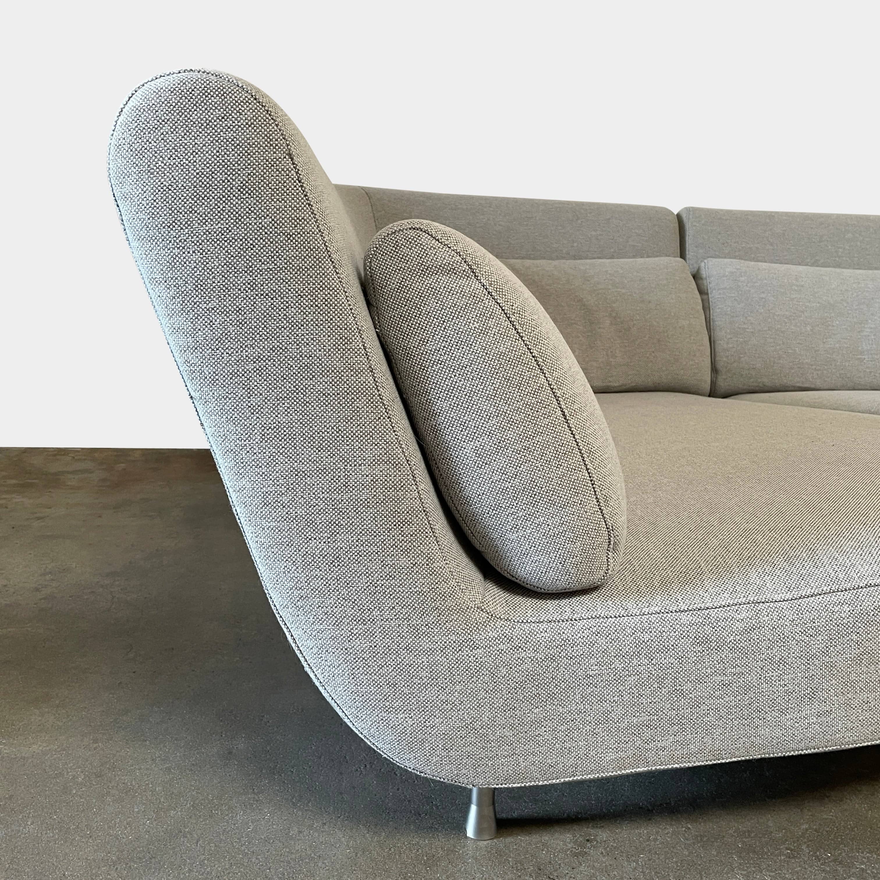 Modern curved Ligne Roset Yang Sectional sofa in durable wool fabric, isolated on a white background.